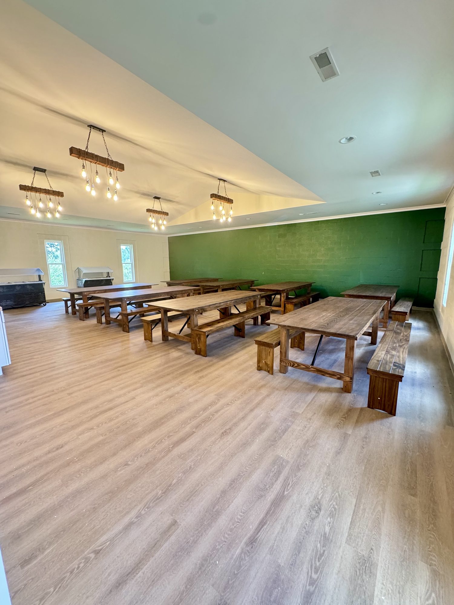 Communal farmhouse-style dining hall with rustic tables