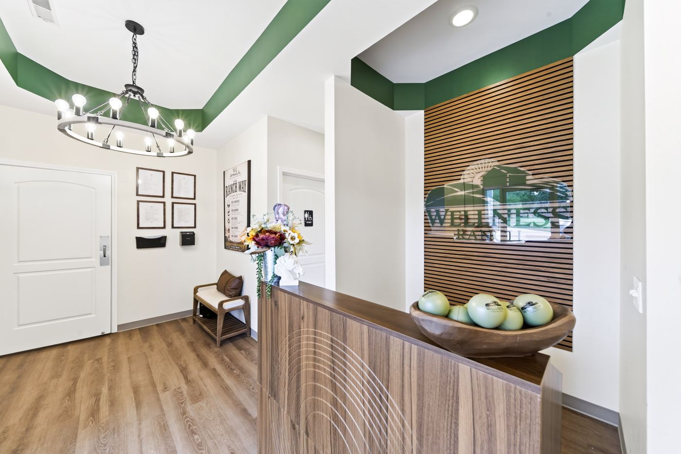 The reception lobby at Wellness Ranch, with a wood front desk and iron ring chandelier